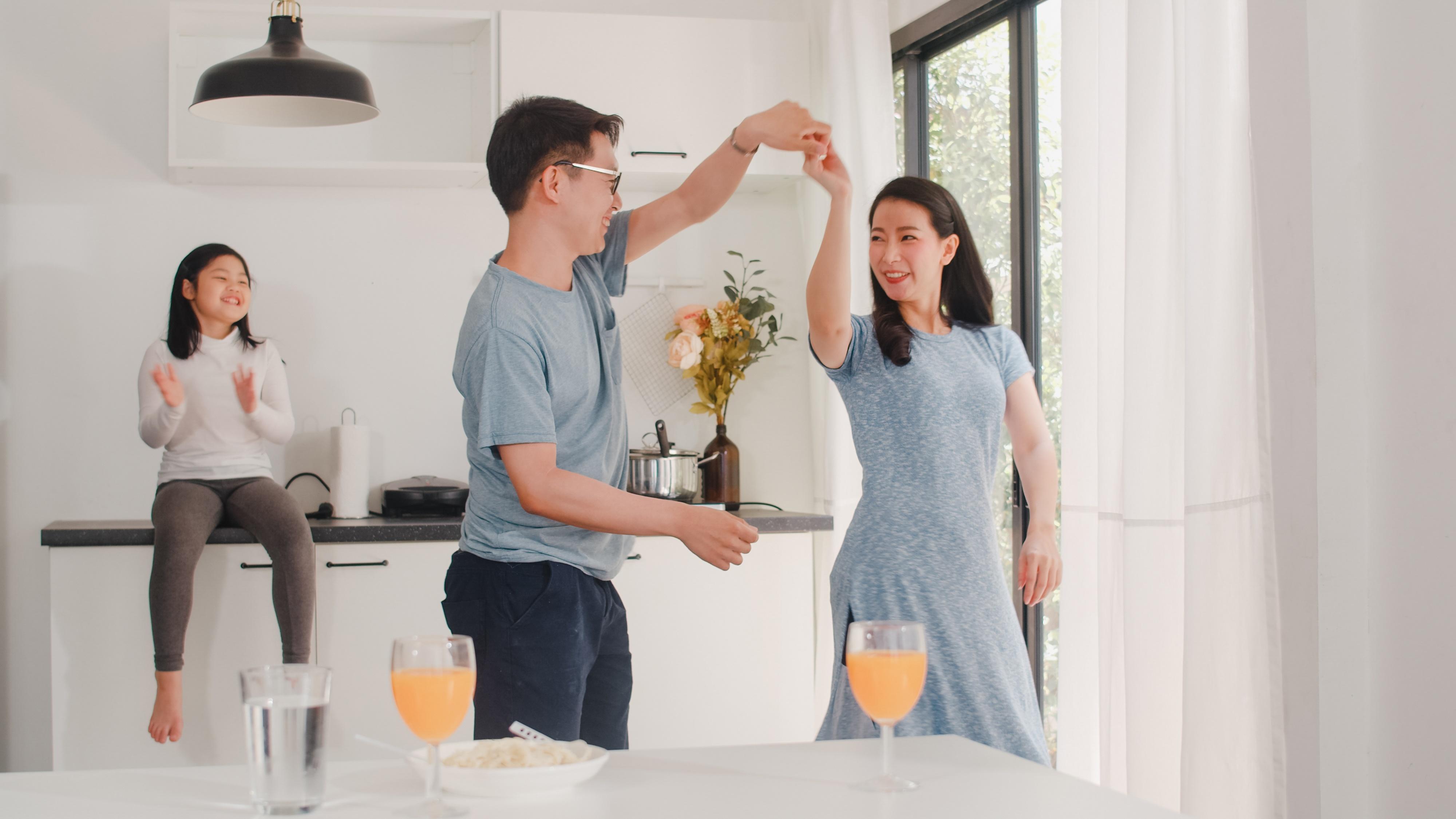 happy young asian family listen music dancing after breakfast home attractive japanese mother father child daughter are enjoying spending time together modern kitchen morning