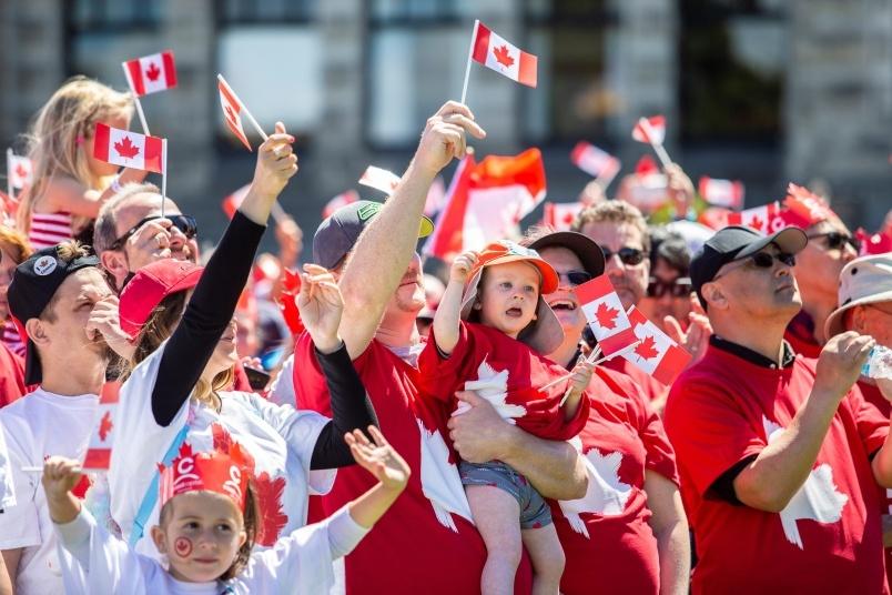 people take part in the living flag on the lawn of the legislature on canada day 1